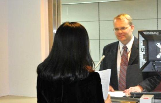 Consular employee talks to a visa applicant